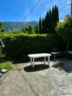 An outdoor patio with a white table and a grill. - Cozy home - near Val Thorens / Orelle (Saint-Julien-Mont-Denis)