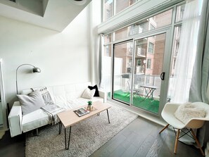 Un salon moderne avec un canapé blanc, une table basse en bois et un fauteuil blanc.