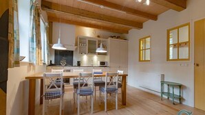 A modern kitchen with wooden beams, a dining area with checkered chairs, and a green side table. - Spacious Coastal Home in Koudekerke (Koudekerke)