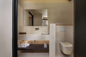 Quarto casal básico de uso individual, vista para o jardim | Banheiro | Chinelos, sabonete, shampoo, papel higiênico