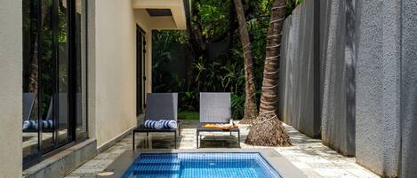 A swimming pool with lounge chairs and a palm tree.