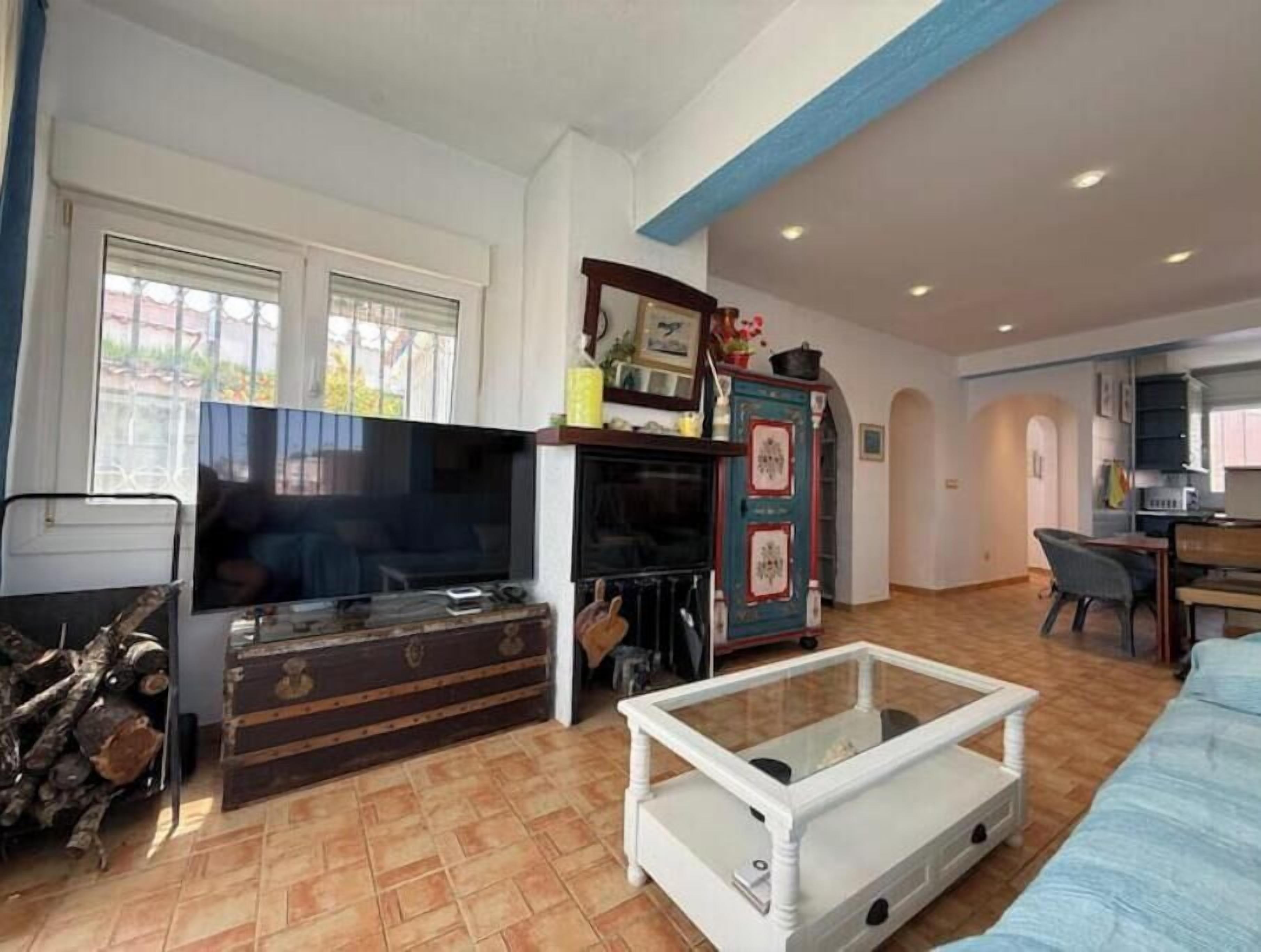 A living room with a television, a coffee table, and a cabinet.