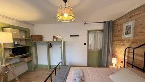 Un dormitorio con cama, mesita de noche, lámpara y pared de madera.