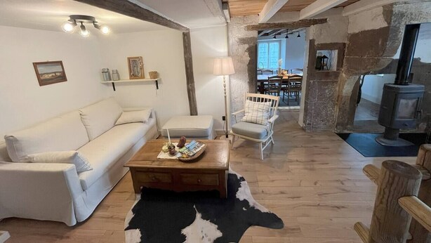 Una sala de estar acogedora con sofá, sillón, mesa de centro y chimenea.