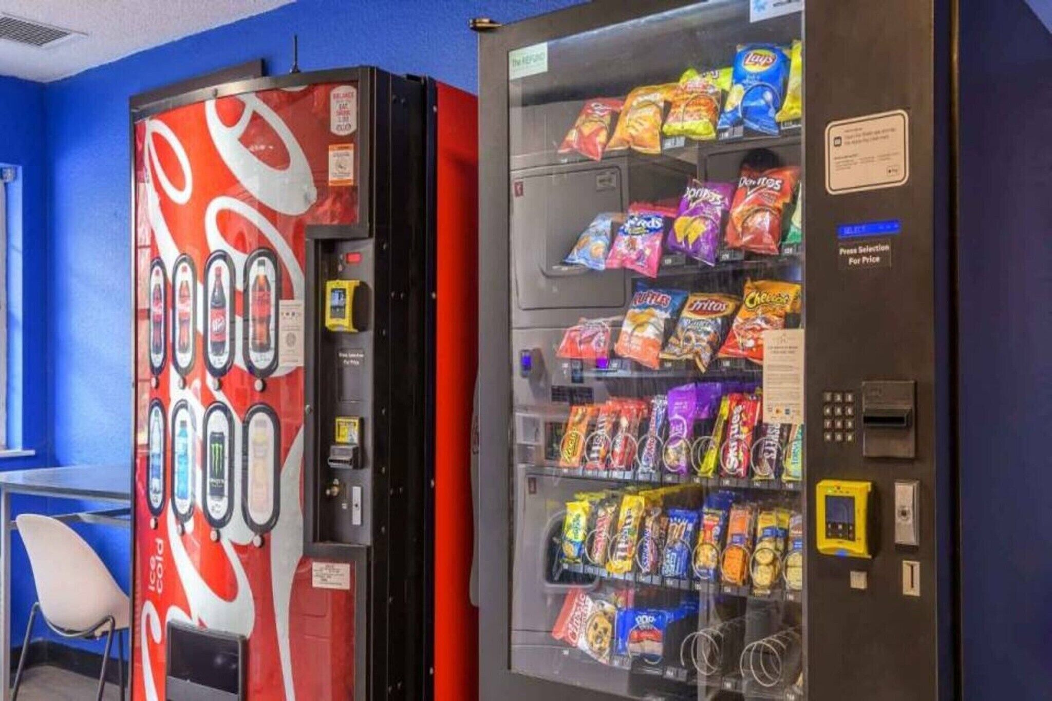A vending machine with snacks and a Coca-Cola branded machine.