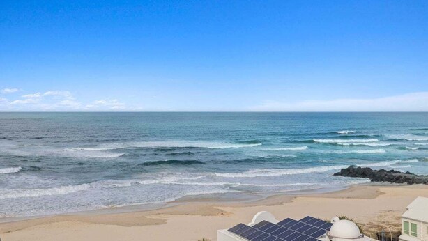 Blick auf einen Strand mit einem Haus und Solaranlage.
