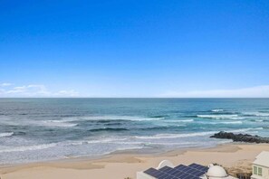 A beach view with a house and solar panels. - Seascape Serenity in Palm Beach (Gold Coast)