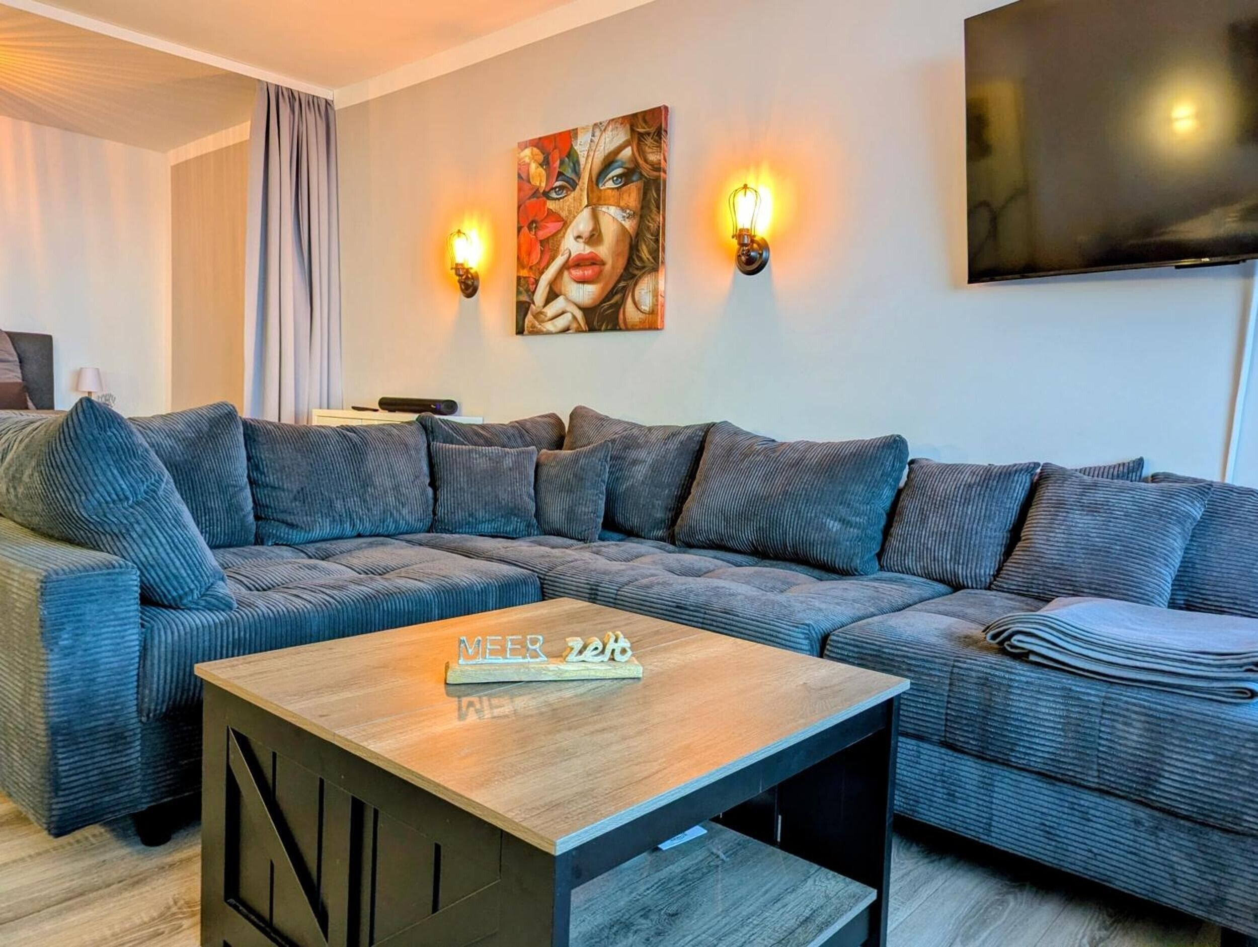 Ein modernes Wohnzimmer mit einem Ecksofa, einem Couchtisch und einem Gemälde an der Wand.