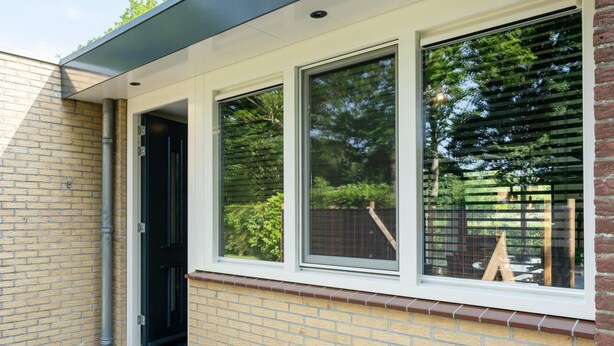 A building with a brick facade, a black door, and a window with a white frame. - 6-person Bungalow With Field Views (Oostkapelle)