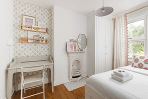 A bedroom with a bed, a desk, a fireplace, and a window with curtains. - New! Elegant 3BR w/Garden near Crystal Palace Park (Greater London)