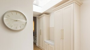 A room with a wall clock, a white wardrobe, and a herringbone floor. - New! Elegant 3BR w/Garden near Crystal Palace Park (Greater London)