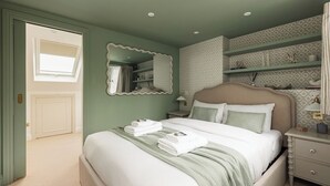 A bedroom with a bed, a nightstand, a mirror, and a wardrobe. - New! Elegant 3BR w/Garden near Crystal Palace Park (Greater London)