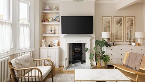 A living room with a fireplace, a television, and a bookshelf. - New! Elegant 3BR w/Garden near Crystal Palace Park (Greater London)
