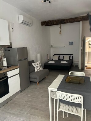 A compact living space with a kitchenette, a sofa, a bed, and a dining area. - MammanaSuite, 3 minutes from Uditore Park (Palermo)