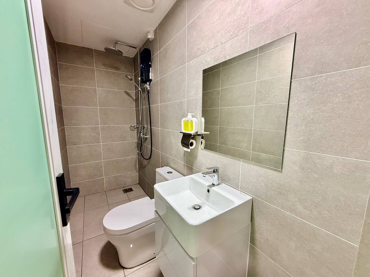 A bathroom with a toilet, sink, and shower.