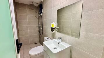 A bathroom with a toilet, sink, and shower.