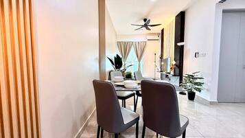 A modern dining area with a table, chairs, and a ceiling fan.
