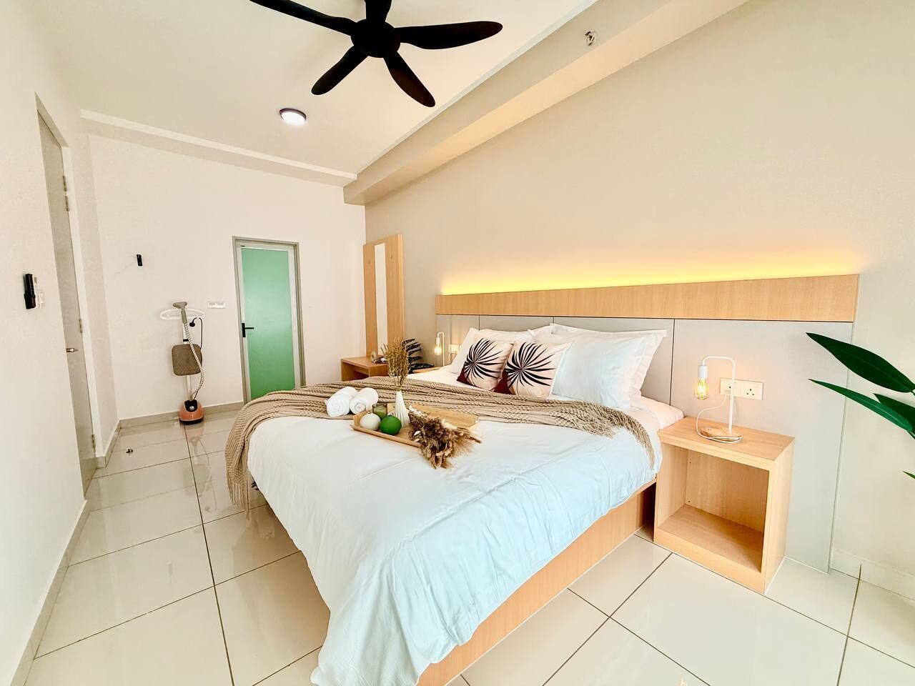A modern bedroom with a bed, bedside table, and a ceiling fan.