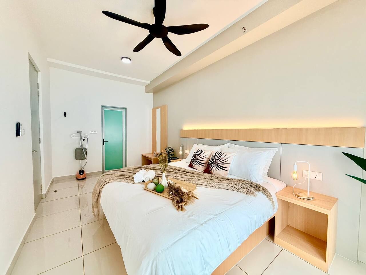 A modern bedroom with a bed, bedside table, and a ceiling fan.