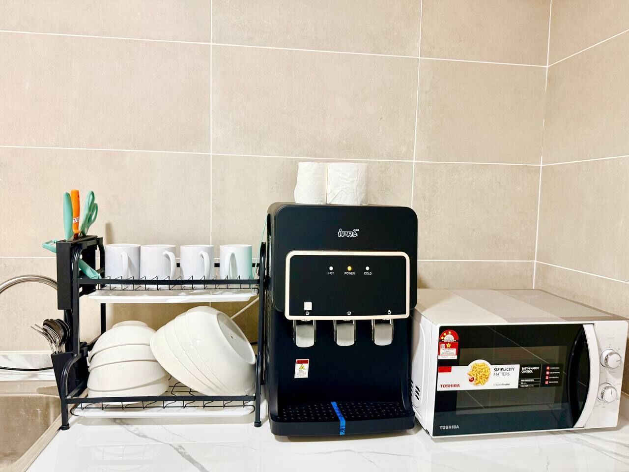 Eine Küche mit Kaffeemaschine, Geschirrgestell und Mikrowelle.