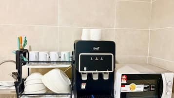 Eine Küche mit Kaffeemaschine, Geschirrgestell und Mikrowelle.
