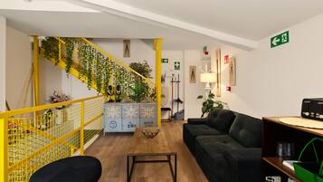A modern interior with a staircase, a sofa, a coffee table, and a bookshelf.