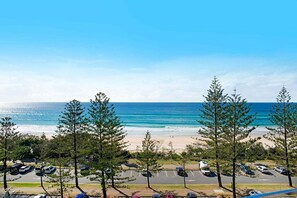 A parking lot with vehicles, a beach, and a clear sky. - Beachside Getaway, Southern Cross Seventh Floor (Gold Coast)