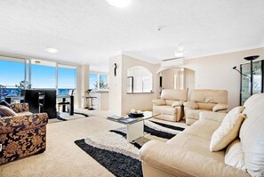 A modern living room with a sofa, armchair, and a coffee table. - Beachside Getaway, Southern Cross Seventh Floor (Gold Coast)