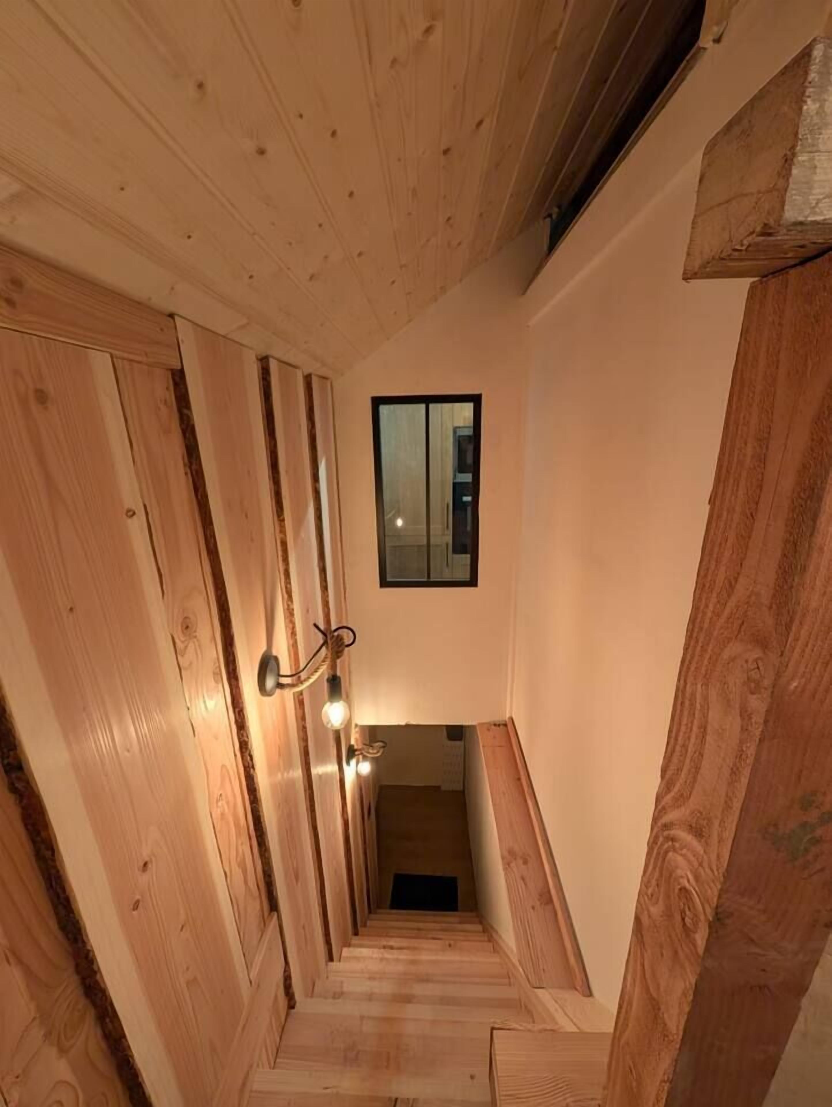 A wooden staircase with a small window at the top.
