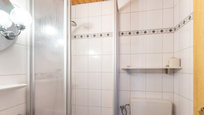 Un bany amb dutxa, vàter i rentavaixelles.