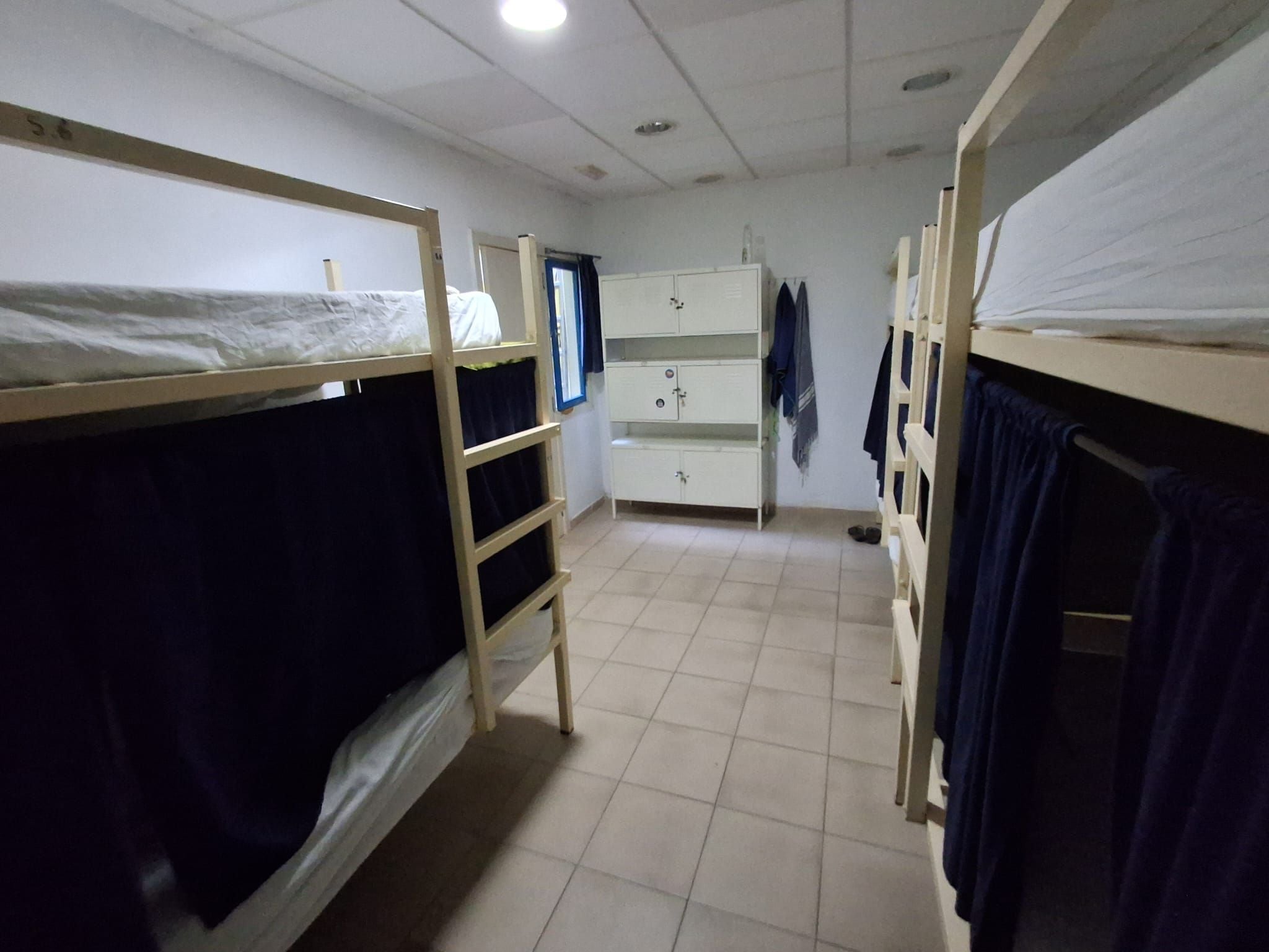 Un dormitorio con literas, un armario y un escritorio.