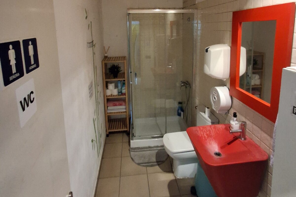 A bathroom with a shower, toilet, and sink.