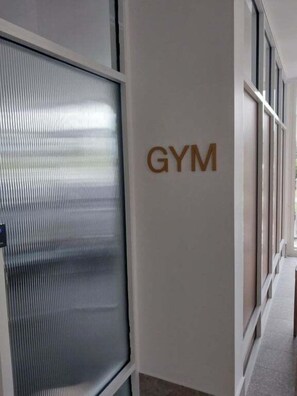 Um corredor com uma placa na parede indicando 'GYM'.
