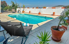 Une piscine avec une chaise et des plantes en pot sur une terrasse sur le toit.