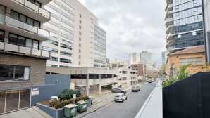 Straatbeeld met moderne gebouwen, een parkeergarage en een heldere lucht.