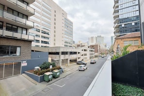 Straßenansicht mit modernen Gebäuden, einer Parkgarage und blauem Himmel.