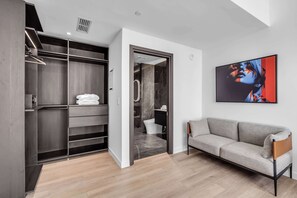 A modern interior with a walk-in closet, a gray sofa, and a large abstract painting. - Skyline Miami & Resort Amenities (Miami)