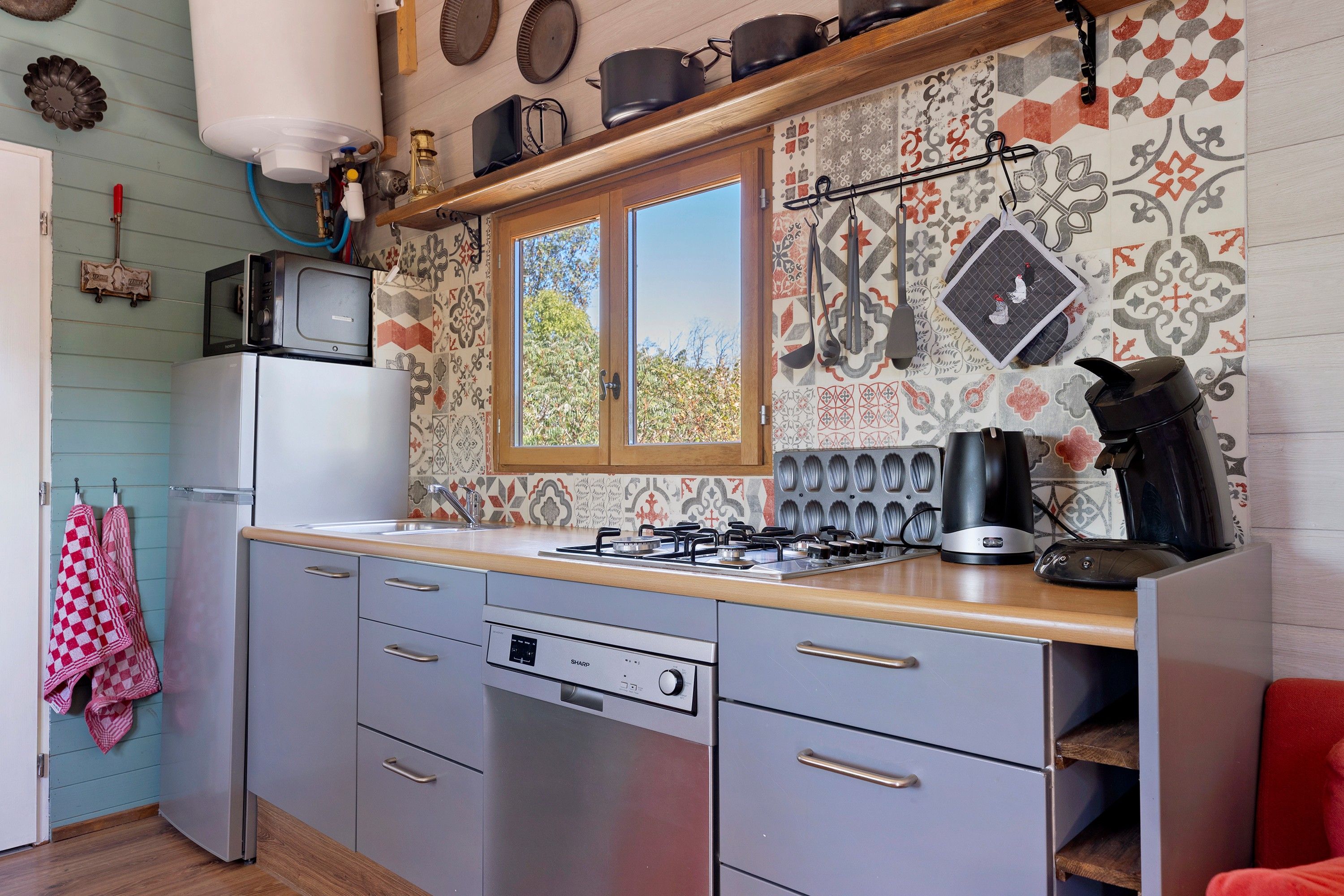 A kitchen with a gas stove, a microwave, and a refrigerator.