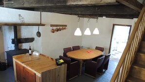 Eine rustikale Küche mit einer Holzinsel, einem Herd und hängenden Töpfen.