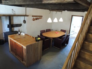 A rustic kitchen with a wooden island, a stove, and hanging pots. - Cottage 'Gîte Grand-mère' with Private Pool, Terrace, and Wi-Fi (Charron)
