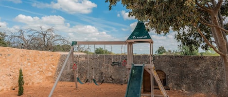 A playground with swings, a slide, and a climbing structure.
