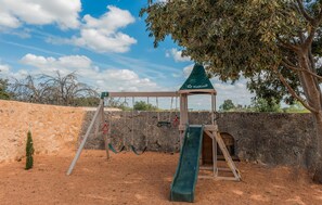 A playground with swings, a slide, and a climbing structure.