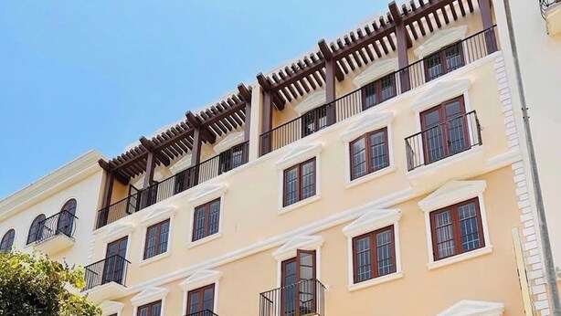 Un edificio de varios pisos con un restaurante en la planta baja y un letrero de hotel.