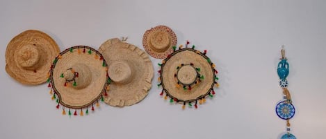A collection of woven hats and a keychain with a blue pendant.
