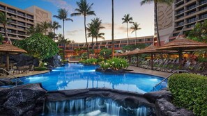 A resort pool with a waterfall feature, surrounded by palm trees and lounge chairs. - Studio Ocean Front at Marriott's Maui Ocean Club - Molokai, Maui, & Lanai Towers (Lahaina)
