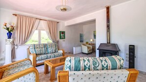 Ein Wohnzimmer mit einer Couch, einem Sessel und einem Kamin.