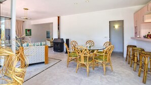 Ein modernes Wohnzimmer mit Essbereich, Kamin und Küche.