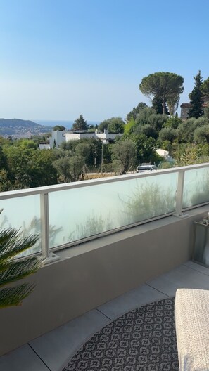 A balcony with a view of a hillside, a building, and a distant landscape. - Luxury Apartment in Nice – Sea and Mountain Views, Near Monaco (Nice)