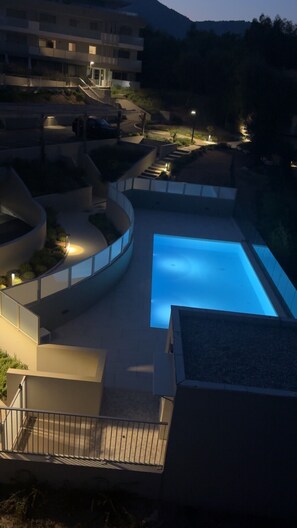A swimming pool with a curved deck, surrounded by a low wall and a fence. - Luxury Apartment in Nice – Sea and Mountain Views, Near Monaco (Nice)