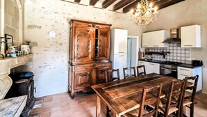 A rustic kitchen with a wooden table and chairs, a built-in cabinet, and a chandelier. - Gorgeous home in Channay-Sur-Lathan with WiFi (Channay-Sur-Lathan)